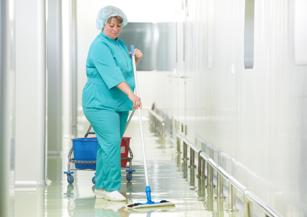 Professional medical cleaning team in exam room following CDC procedures